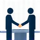Two people shaking hands across a desk.